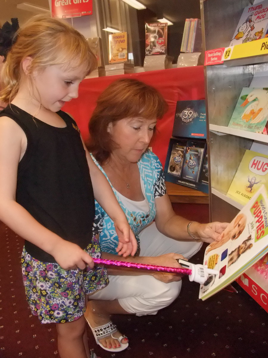 Image: What Book Do I Want? — First grade teacher Charlotte Morgan peruses the books.