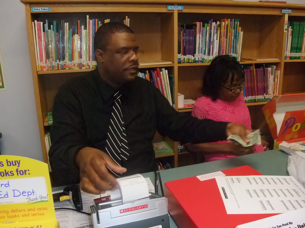 Image: Another Sale! — Many books were being purchased. Mr. Billy Burkhalter helps out as a cashier.