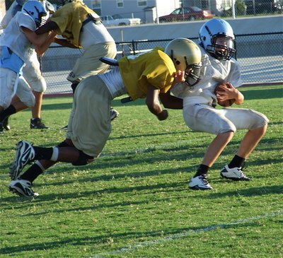 Image: Stopped in his tracks — Safety Trevon Robertson delivers a hard hit to the Cougars backup quarterback during the JV scrimmage.