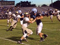 Image: Illegal stiff-arm — Waco Reicher’s quarterback illegally grabs and twists the facemask of Italy’s Justin Buchanan but the referees missed the call. It’s all part of the game.
