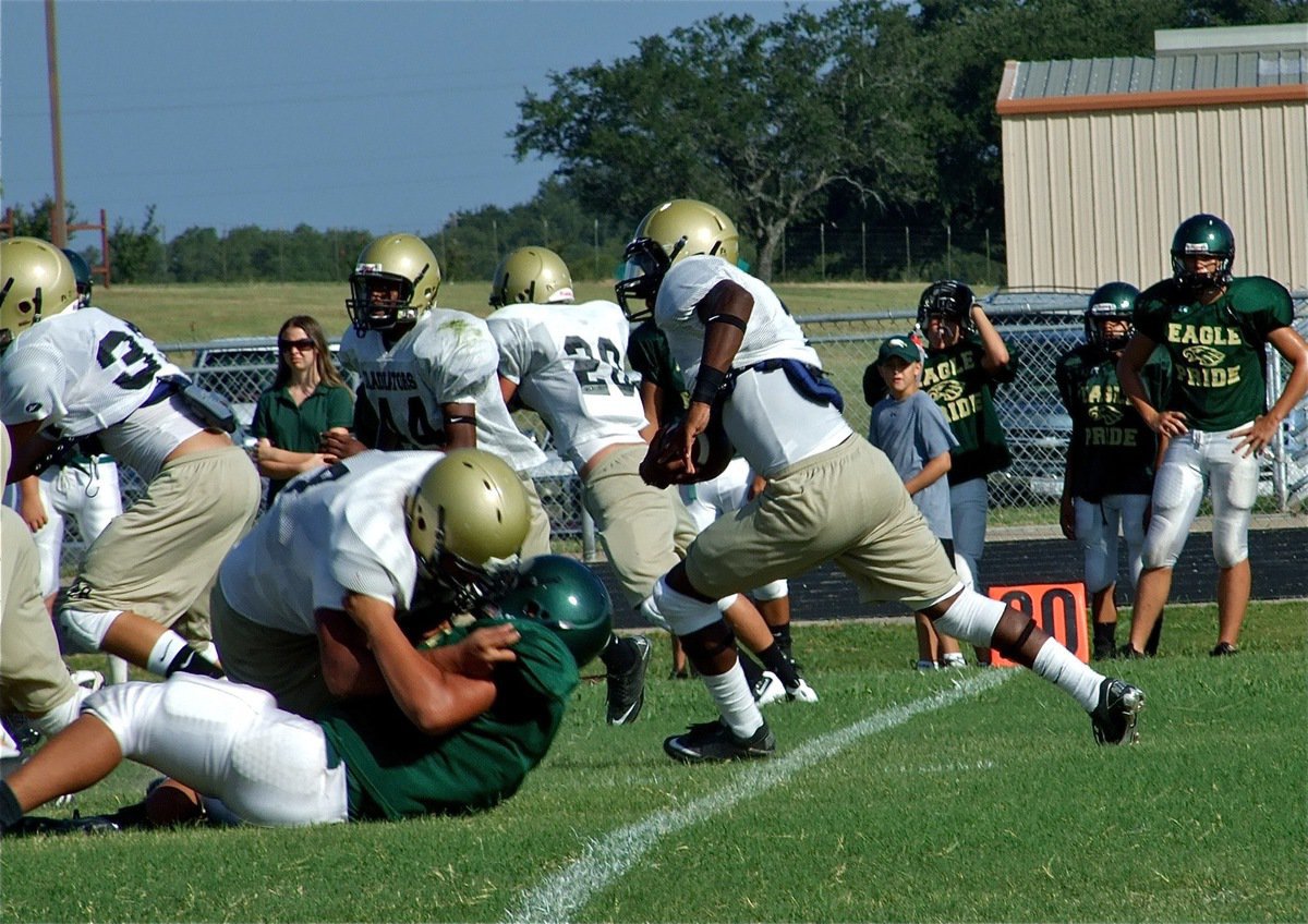 Image: Nice block — Lineman Omar Estrada pancakes an Eagle defender to create a running lane for Jasenio Anderson.