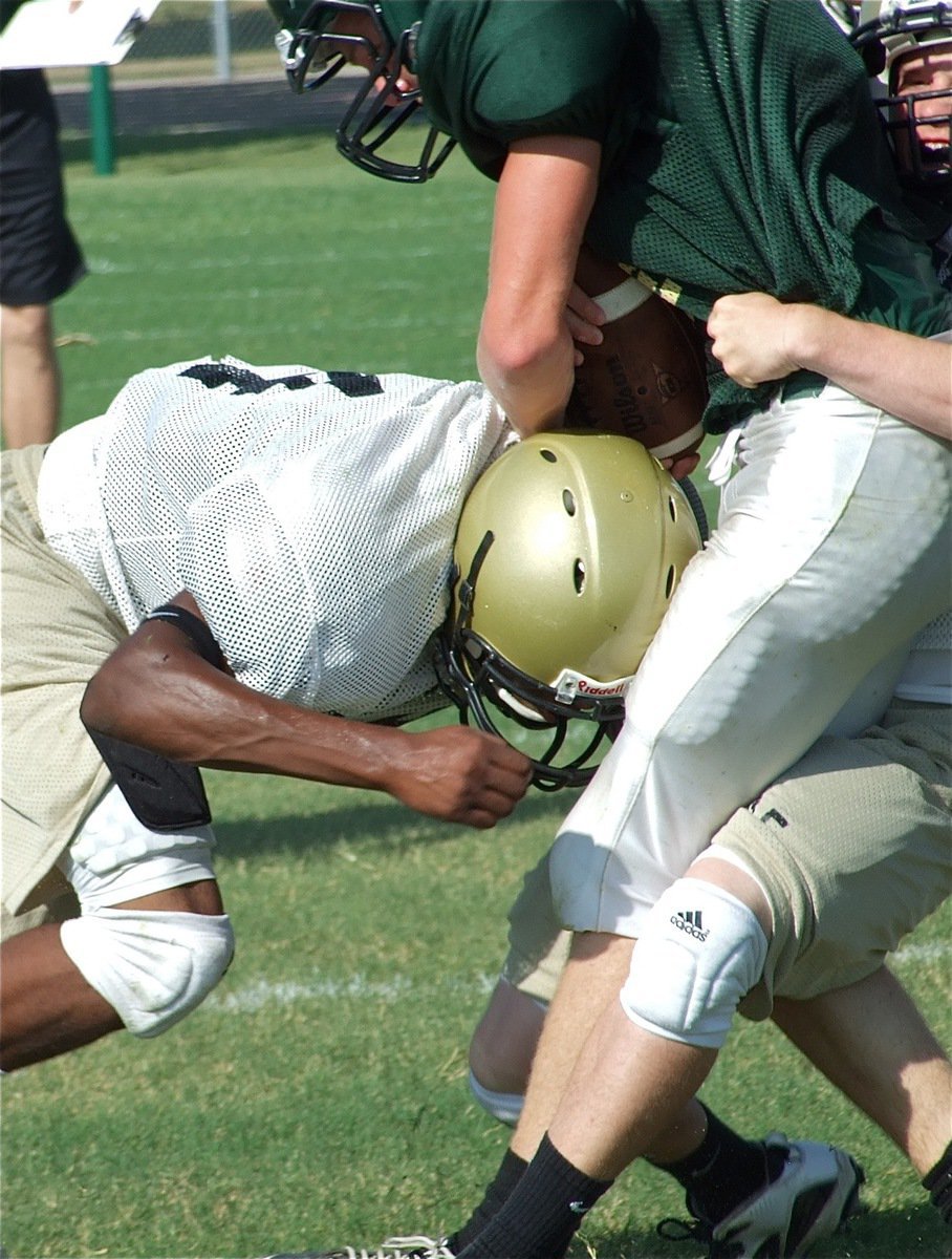 Image: High and low — Italy’s Justin Buchanan hangs on to this Eagle running back as De’Andre Sephus delivers a shot.