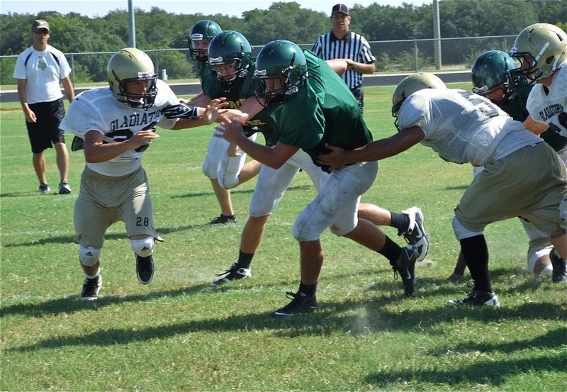 Image: Closing the door — Kyle Jackson(33), Jacob Lopez(52) and Ethan Simon(60) converge on an Eagle running back.