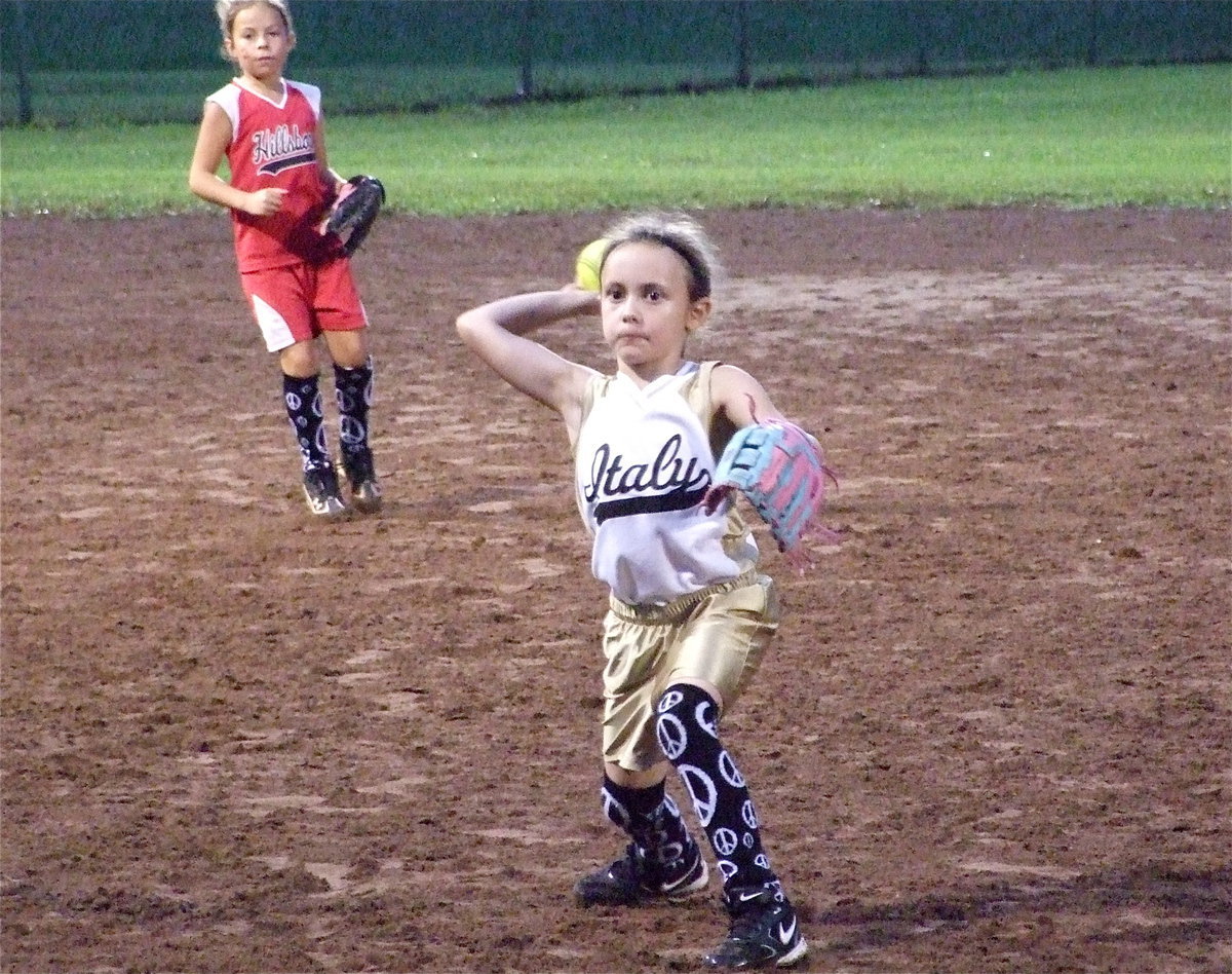 Image: Grace makes plays — Italy’s second baseman Grace Payne throws to first base for three straight outs against the Ferris Scorpions but the Scorpions held on for a 3-run win, 15-12, knocking Italy out of the tournament. Also pictured is Hillsboro’s MaKenzie “Hollywood” Wallace, a pick-up player Italy added to their roster for tournament play.