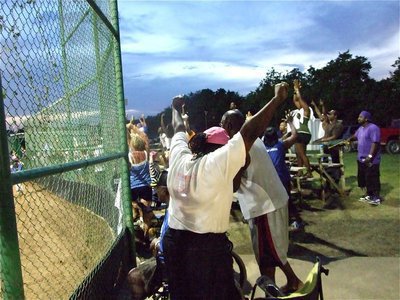 Image: Celebration begins — Kieauna Hurtt’s hit to score Sarah Sanders from third base allows Milford’s fans to start the district tournament championship celebration.