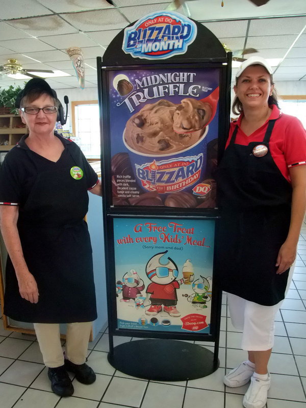 Image: Corky Wright and Shari Phillips — Corky Wright (long time DQ employee) and Shari Phillips (DQ manager) keeping cool by the Blizzard sign.