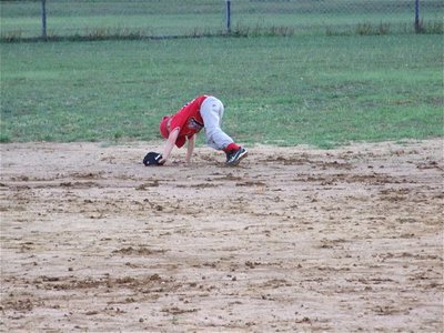 Image: T-Ball is fun — This IYAA T-baller plays in the mud before heading into the outfield.