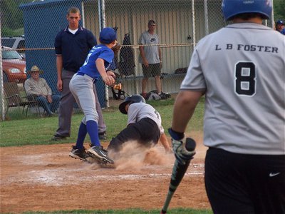 Image: Justin slides home — Justin Wood slides home to register his second homerun in a row against Whitney as John Byers(8) looks on from the batter’s circle.