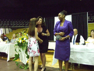 Image: A special treat — Volleyball coach, Andi Windham, receives thanks from daughter, Drew and Jaleecia Fleming.