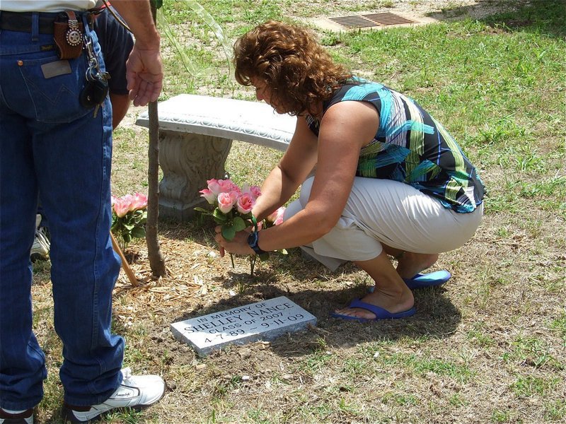 Image: Adding flowers — Shelley’s mother, Cynthia Nance, adds flowers to Shelley’s Memorial Garden and waters them with tears of love.