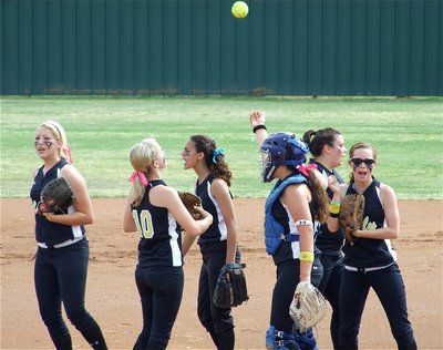 Image: Team ritual — The Lady Gladiators kept each other motivated during the 14 innings it took to win the regional quarterfinal championship over Meridian.