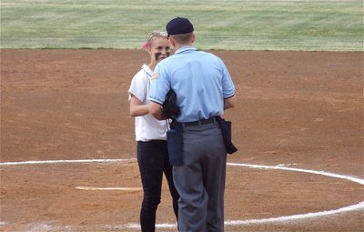 Image: What’s ump? — The umpire exchanges softballs with Lady Gladiator pitcher Courtney Westbrook and a few words as well.