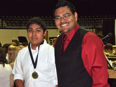 Image: Jaun Suaste — Juan Suaste, a 7th grade trumpet player, receives a medal from IHS Band Director Jesus Perez.
