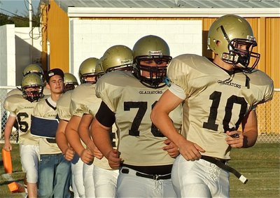 Image: JV takes field — The Italy JV Gladiators enter the Willis Field arena to battle the Blooming Grove Lions.