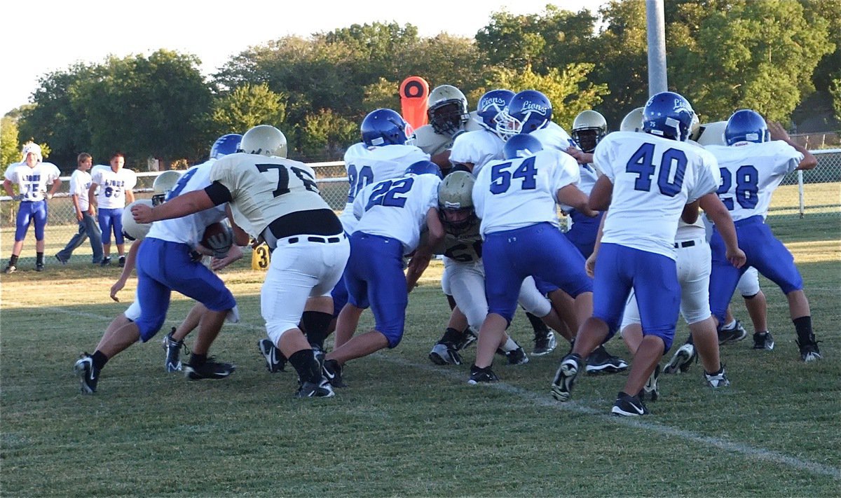 Image: Seabolt tightens grip — Noseguard Hank Seabolt(76) was well suited for the rugby scrum match down the middle of the field. Seabolt had multiple tackles including this one that resulted in a loss of yards for the Lions.