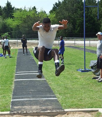 Image: Drop the landing gear — John Isaac drops the landing gear to finish in second place during the triple jump competition.