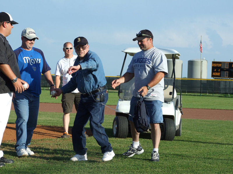 Image: Loyd Davidson sends a strike — Honoree Loyd Davidson, friends and family watch as he sends the first pitch of the game.