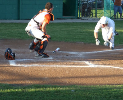 Image: Acrobats at home — Josh Milligan begins his decent to home plate by taking a roll.