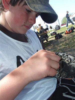 Image: Kyle checks his gear — 7th grader Kyle Fortenberry cleans off his track shoes before his race.