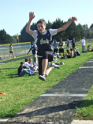 Image: Colton grabs air — 7th grader Colton Petrey gave a strong performance in the triple jump during his district debut.