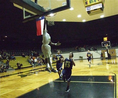 Image: Dunk attempt — John Isaac(10) goes for a high-flying dunk over the Eagles.
