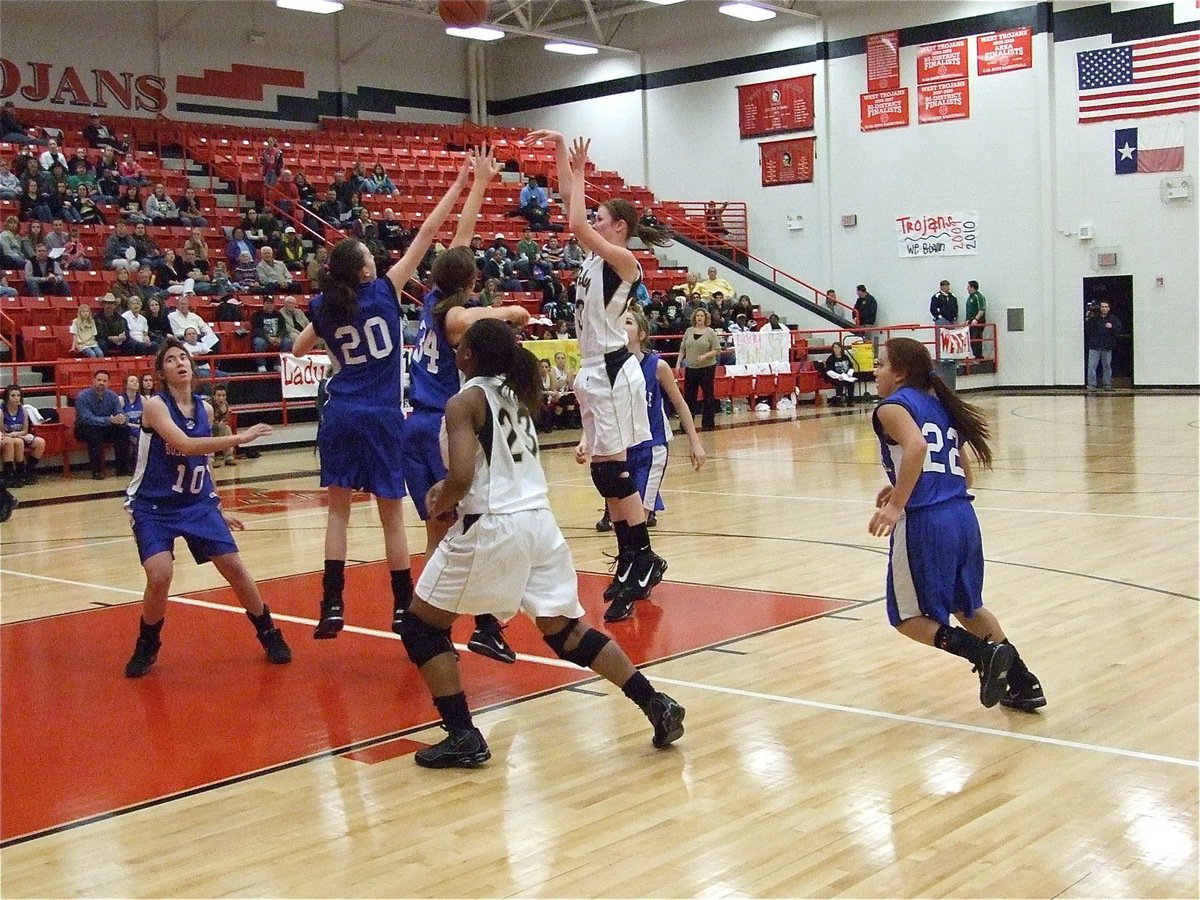 Image: Kaitlyn shoots — Kaitlyn Rossa(3) rises over two Lady Bulldog defenders as Brianna Burkhalter slides in for the rebound.