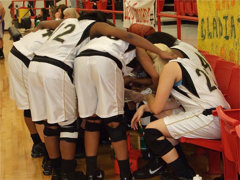 Image: Pulling together — With the bi-district championship hanging in the balance, the Lady Gladiators hang on to one another for strength.