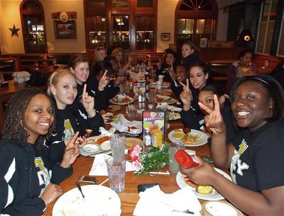 Image: Food of Champions — The Lady Gladiators all hold up the #1 sign while Jimesha Reed asks for seconds.