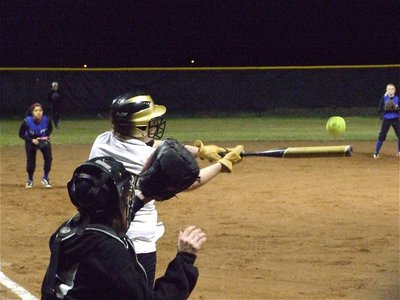 Image: Work gloves on — Julia McDaniel gets to work and sends a pop fly to center field.