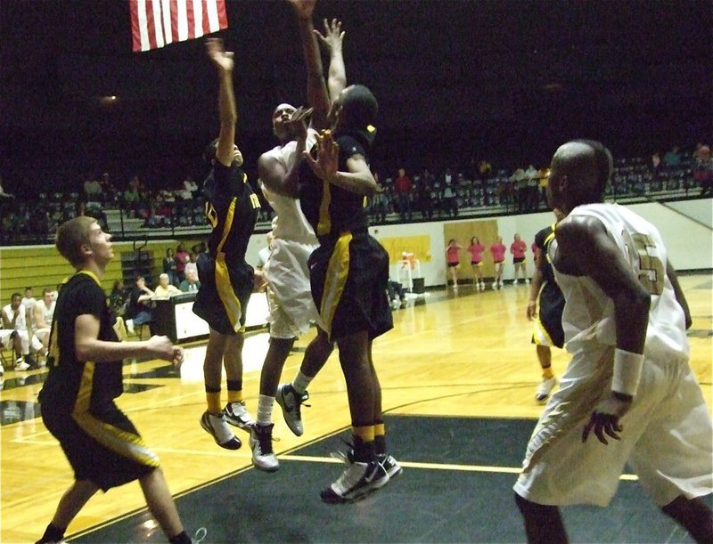 Image: Mayberry’s the man — Center Larry Mayberry scores over an Itasca double-team as Desmond Anderson(15) steps in for a rebound.