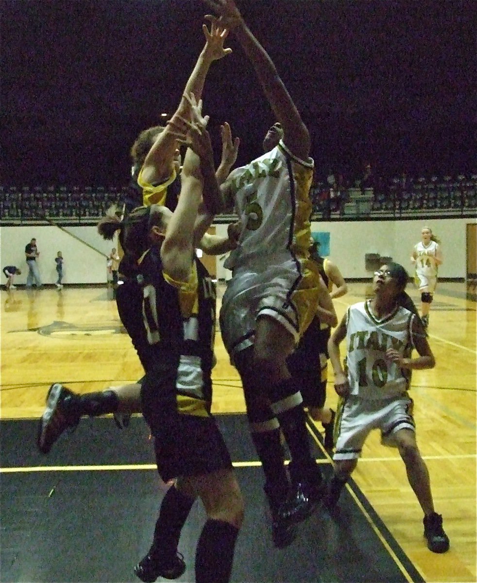 Image: Meeting the challenge — Chante Birdsong(5) rises for a score over two JV Lady Wampus Cats as Lacie Lopez trails the play.