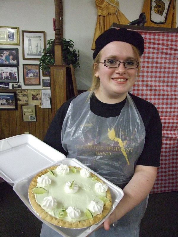 Image: Emily has style — Emily Stiles shows off the keylime pie that was auctioned for $150.  The Gladiator Regiment Band sponsored “Oodles of Noodles” Spaghetti Dinner at the Uptown Cafe Saturday night.  All proceeds go towards the band’s expenses during the year.
