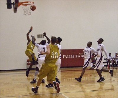 Image: Getting the shot up — Desmond Anderson(15) floats along the baseline while Jase Holden(33) hurries in for the rebound.