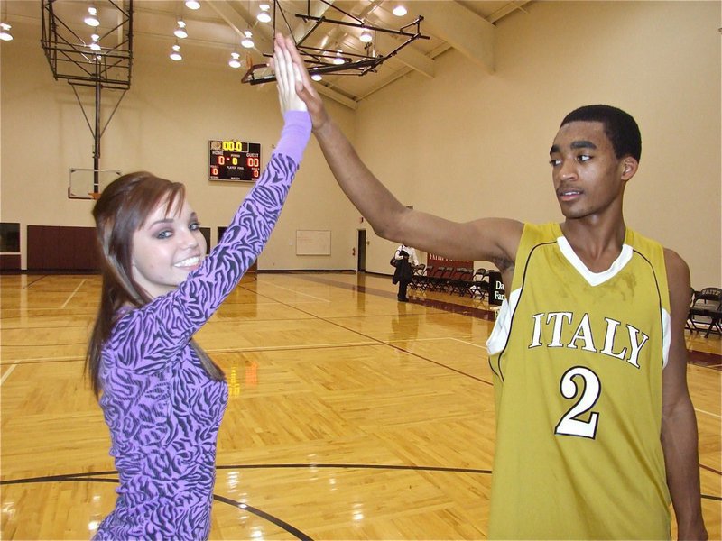 Image: Great job! — IHS cheerleader Drew Windham gives Heath Clemons(2) a high five after Italy’s 80-35 victory over Dallas Faith Family.