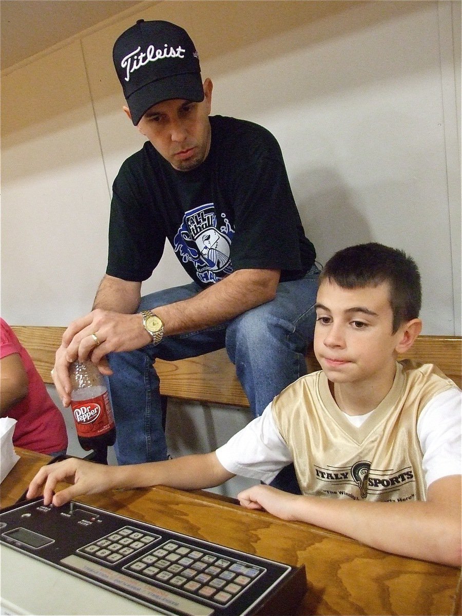 Image: Learning the craft — Trevor Mott gets a lesson from his dad on how to operate the clock.