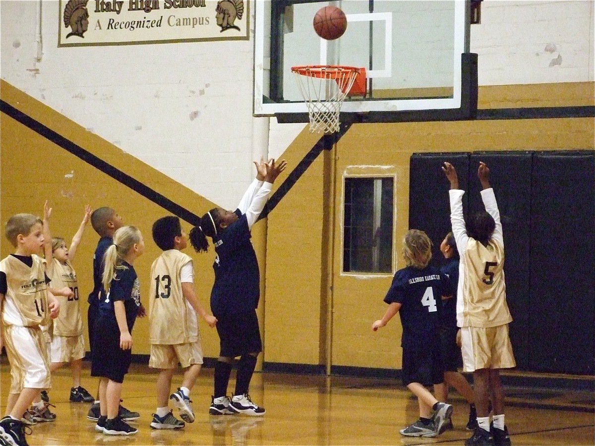 Image: Putting up a shot — Kambria Brooks(5) shoots while Reese Janek(14), Jacee Coffman and Michael Gonzalez(13) go for the rebound.