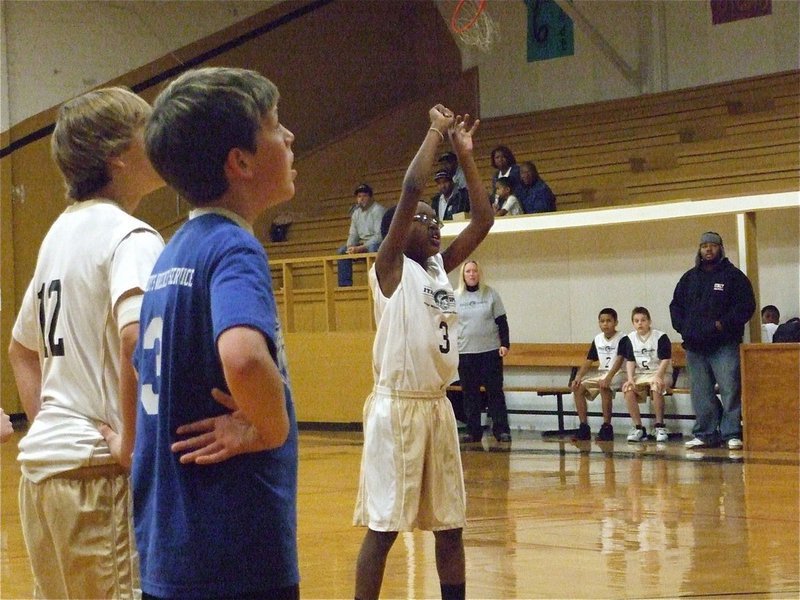 Image: From the line — Michael Wilson(3) attempts a free throw as Lance McClendon(12) catches his breath.