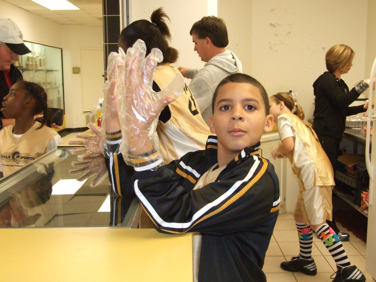 Image: Lending their hands — IYAA players Tylan Wallace, Janae Robertson(23) and Peyton Henderson(2) lend their helping hands to Darla and Gary Wood in the concession stand.