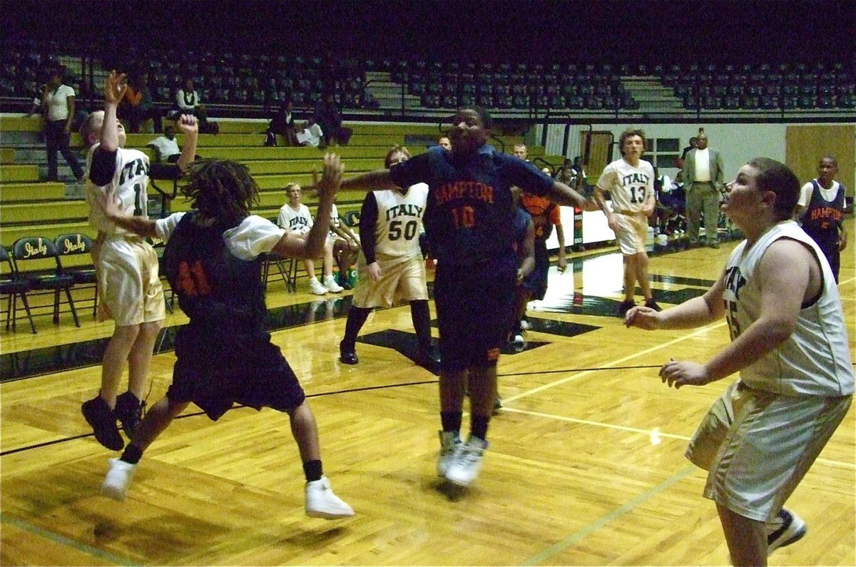 Image: J.T. from the baseline — J.T. Escamilla(12) tries to shoot while the Pheonix defense flies at him.