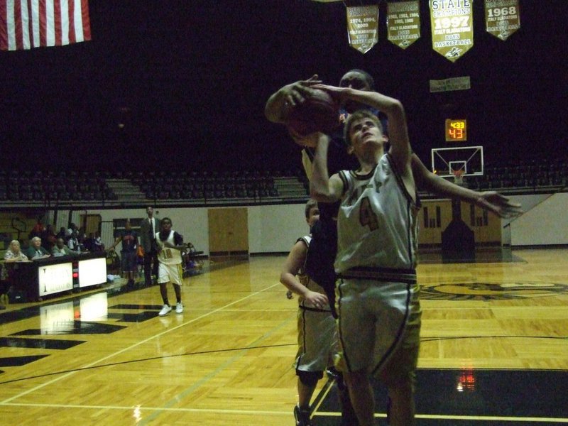 Image: Justin gets challenged — Justin Wood(4) just kept going, and going, to the basket.