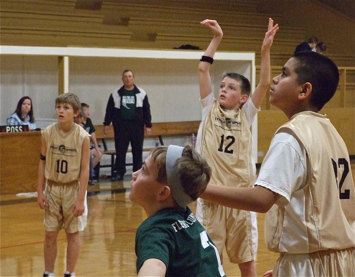 Image: Ty Windham puts touch on the ball against Hillsboro Green — Ty Windham(12) attempts a free throw against Hillboro Green while his Italy 30 teammates Caden Petrey(10) and David De La Hoya(32) prepare to rebound.