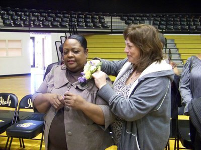 Image: Corsage with purple ribbon of course! — Jennifer Bales helps Moreland with her corsage.