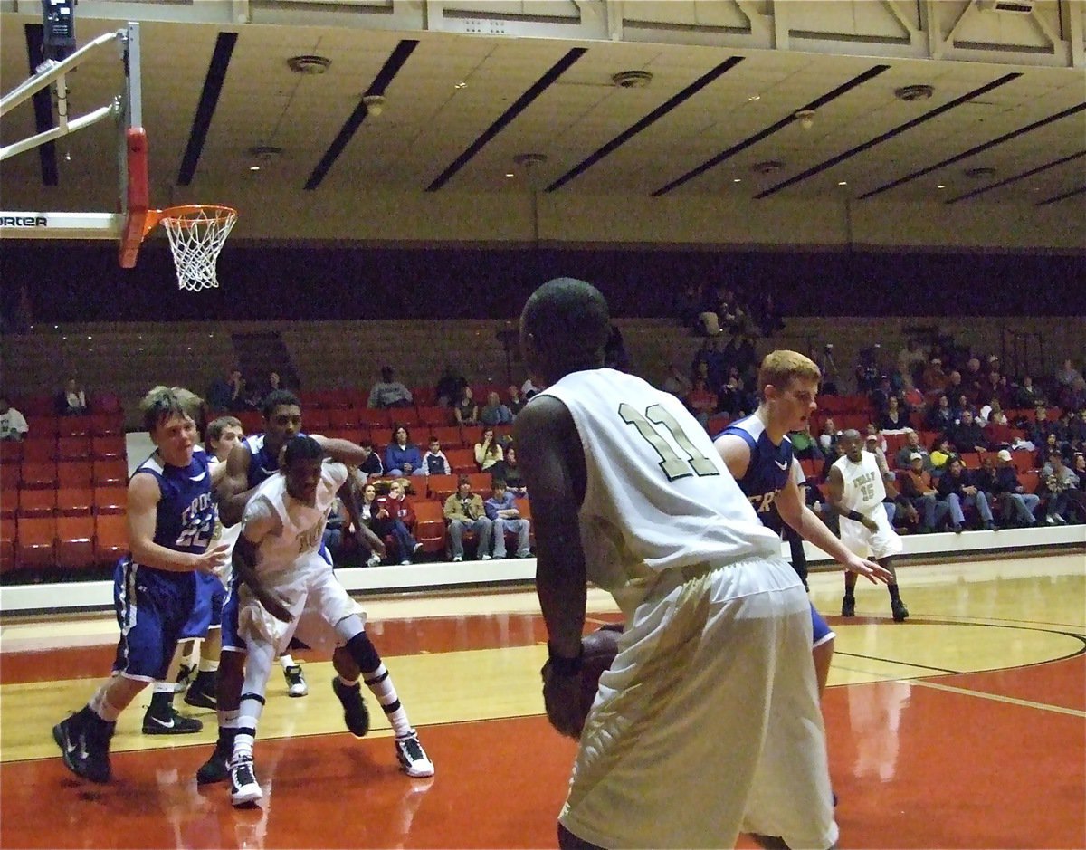 Image: Spotting up for three — Jasenio Anderson(11) takes aim at a 3-point shot while teammate John Isaac(10) holds back the Polar Bears.