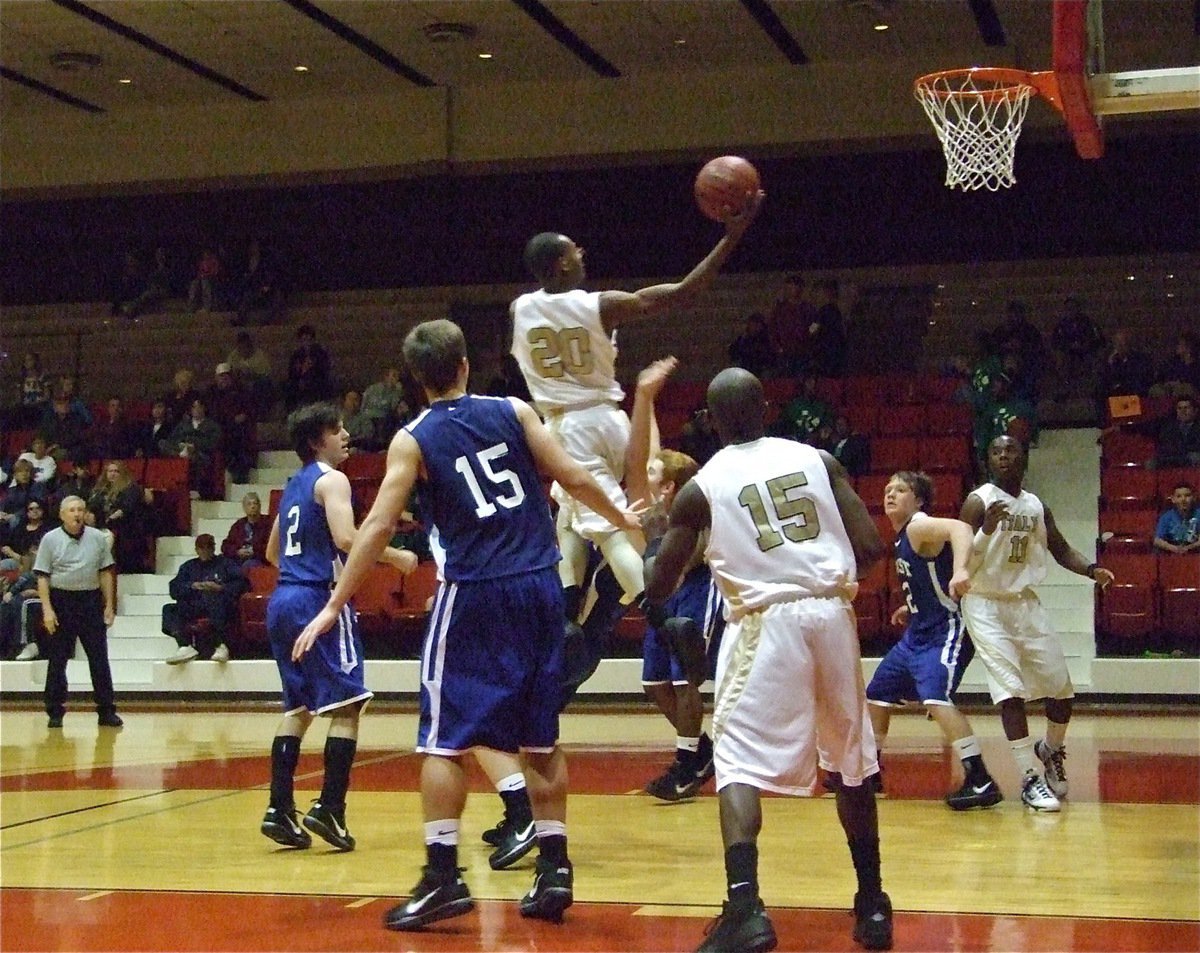 Image: Sephus soars — De’Andre Sephus soars into the face of the Frost Polar Bear’s defense while Desmond Anderson(15) and Jasenio Anderson(11) move in for the rebound.