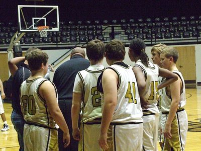 Image: 8th grade talks it over — Trying to hold on to their first half lead, the 8th grade team huddles with their coaches.