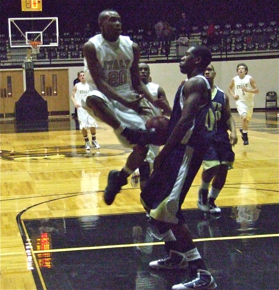 Image: Sephus gets bumped — Deandre Sephus(20) gets bumped on on his way to the rim but still managed 4-points in the close contest.