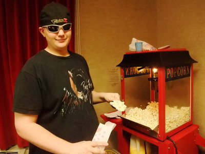 Image: Popcorn Anyone? — This young man is happy to scoop up popcorn for everyone.