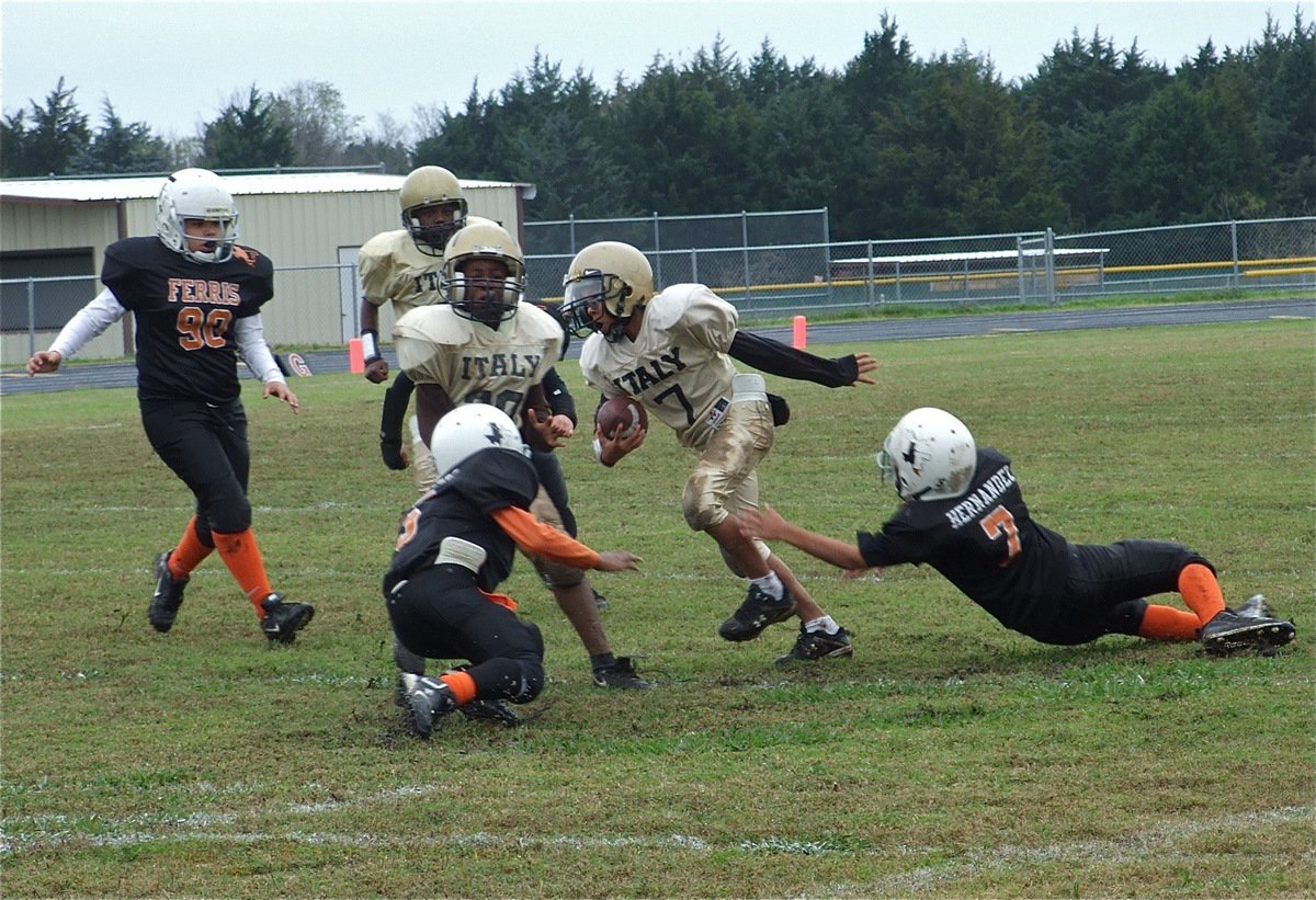 Image: Tylan sheds tackler — Italy’s Tylan Wallace(7) swats away Ferris Yellowjacket tacklers.