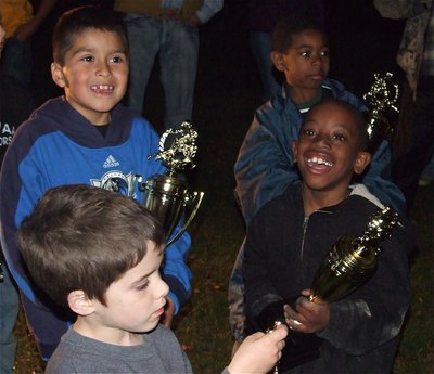 Image: “Superbowl Champs!” — Michael Gonzalez (top left), Tyvon Gates (top right), Dustin Rose (bottom left) and Joe Jackson were all smiles as they received their trophies during the IYAA Bonfire Party.