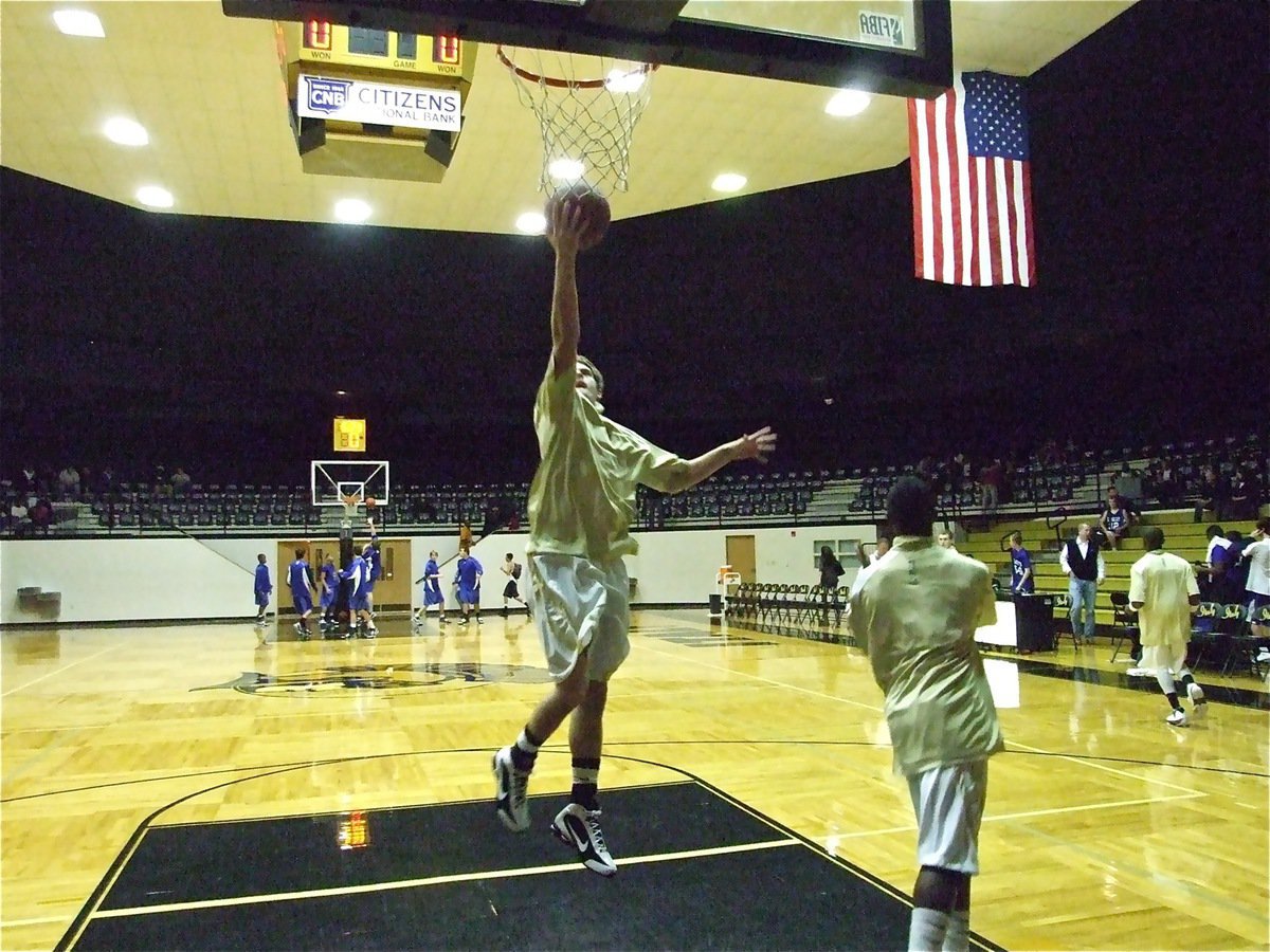 Image: Ryan warms up — Ryan Ashcraft overcomes a recent dislocated finger received against Itasca in football to join his team at the start of the season in basketball.